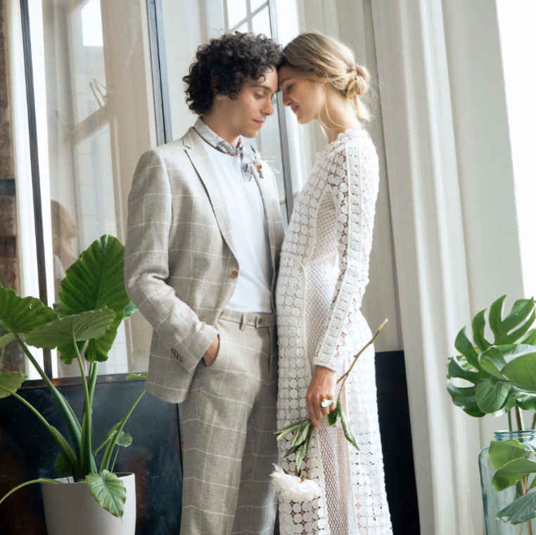 hochzeitsmode 1 mann-schaut-laechelnd-in-die-kamera-mit-hochzeitsanzug